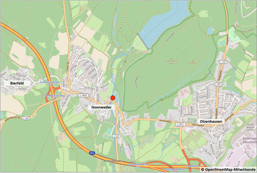 Eine Karte mit der Lage der Maßnahme. Die Kurhalle liegt am Ortseingang des Ortsteils Nonnweiler an der Verbindungsstraße zum im Osten gelegenen Ortsteil Otzenhausen. Die Maßnahme liegt direkt am Fluss Prims. Dahinter sind mehrere Erhebungen zu erkennen, insbesondere der angrenzende Kahlenberg mit 564 m.
